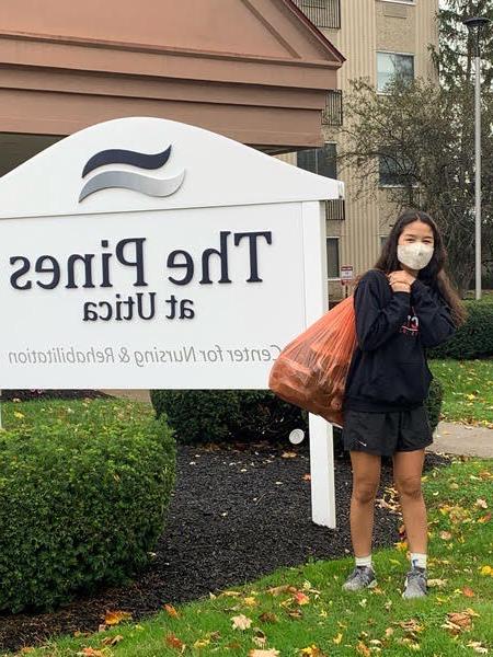 Young scholars student poses as she collects donated sneakers for our “Got Sneakers” 社区 Service Project